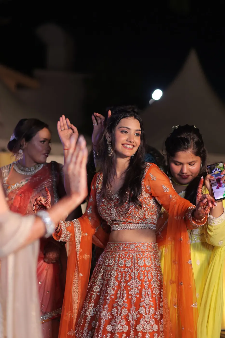 Guests dancing in colorful traditional outfits at a South Asian wedding celebration